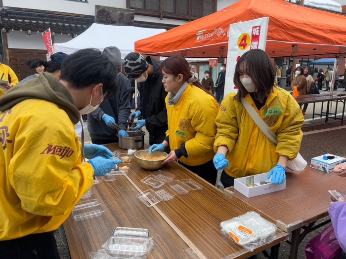 餅にきな粉やあんこをまぶして販売する学生たち