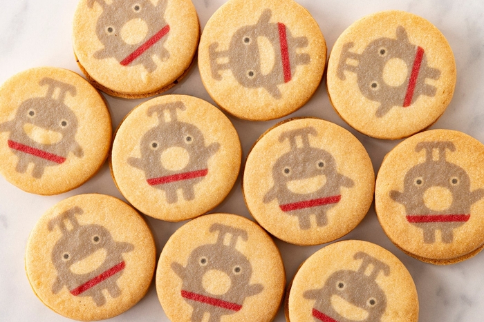 カカオ分の高いクーベルチュールを使ったチョコレートクリームをサクサクのサブレに可愛らしい表情の「のるるん」を乗せてサンドしました。  東急電鉄株式会社商品化許諾済 ー東急線キャラクター のるるんー