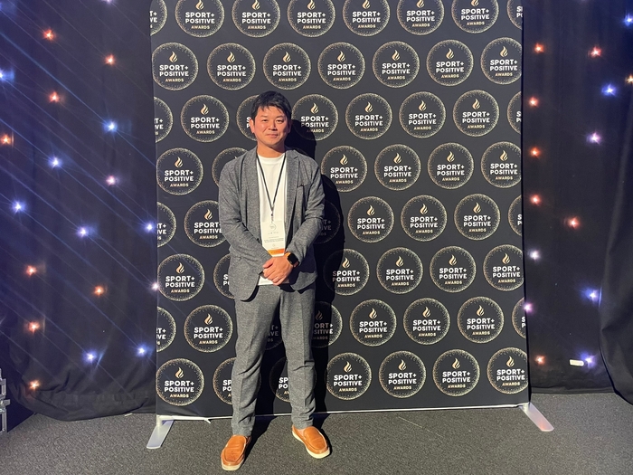 Summit内表彰式会場内のSport Positive Awardsパネル前にて代表理事松下