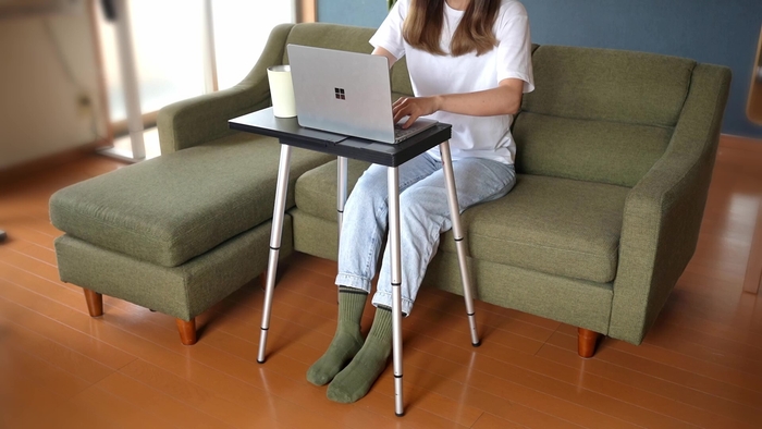 画像6 室内のソファに座りタイピングする女性