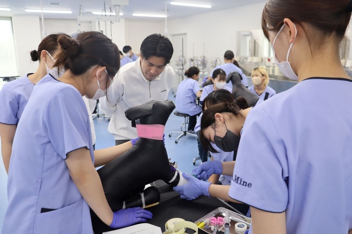 装置の使い方をアドバイスする石橋さん(中央奥)