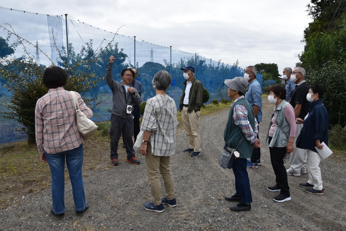 果樹園を紹介する中尾准教授(左から2人目)