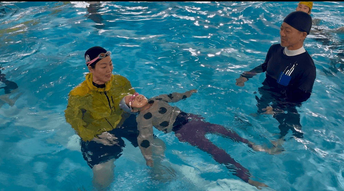 コーチに浮き方を教わる参加者