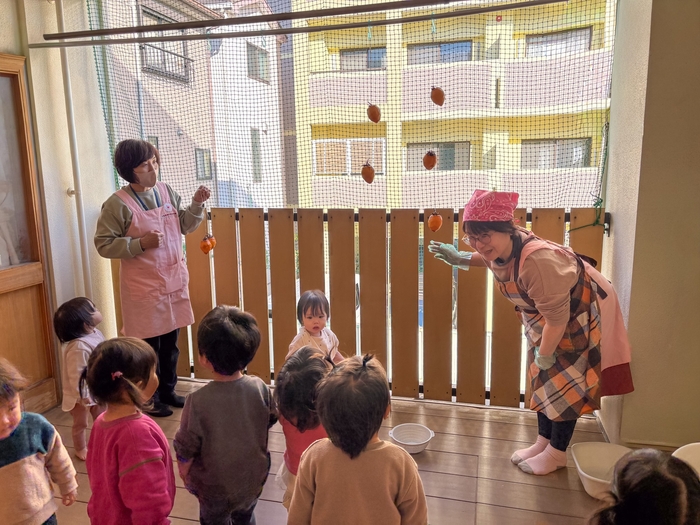 テラスで柿を吊るす様子