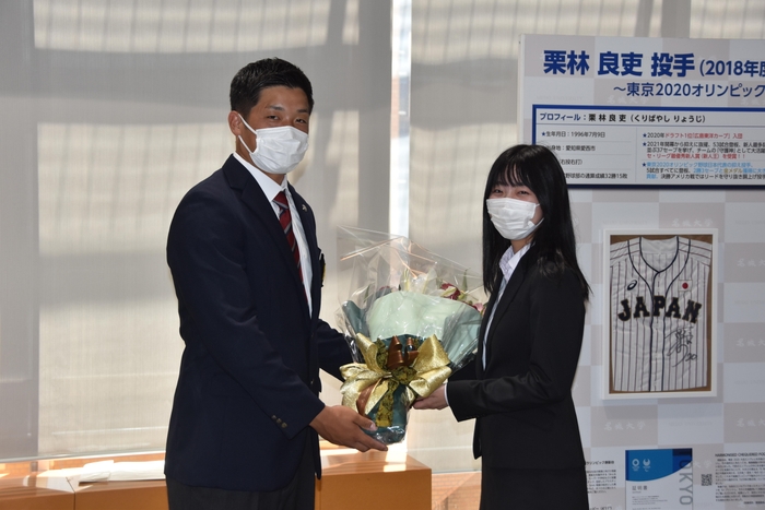 野口捕手に花束を贈るマネージャーの鬮目芙実佳さん(経営学部2年)