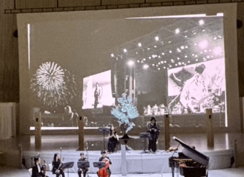 音楽劇「我ら地球人〜ダディとマザーの物語」公演より(スクリーンに9/26開催ライブ時の花火風景)
