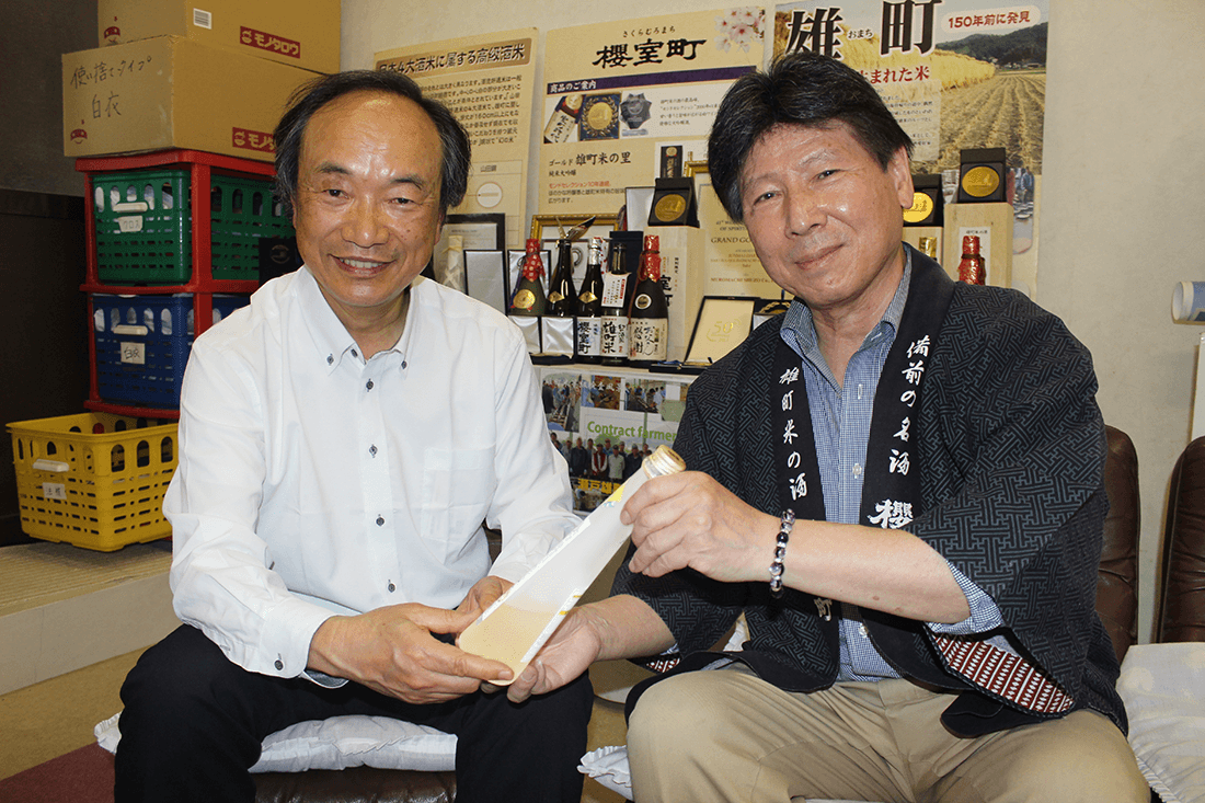 サクラ酵母で造った日本酒を手にする滝澤教授(左)と花房社長(右)