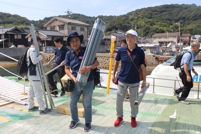 船で運び込んだ機材を真鍋島に陸揚げする辻教授(中央)ら一行