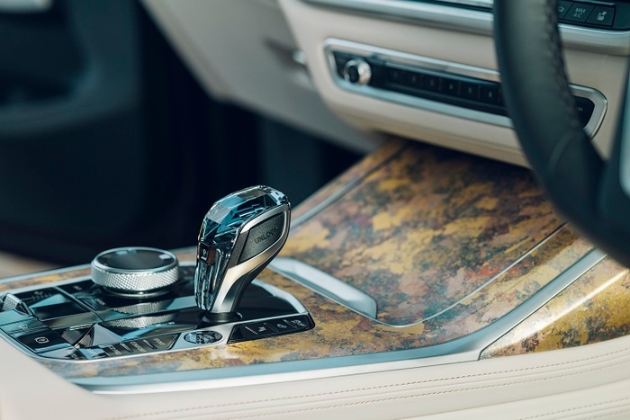 革の表面に箔を施して裁断し、絹の経糸と織り上げるという独自の技法を用いたフロント・アームレスト