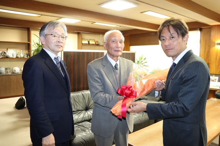 加計理事長(右)から花束を贈られる善木名誉教授(中央)。左は平野学長