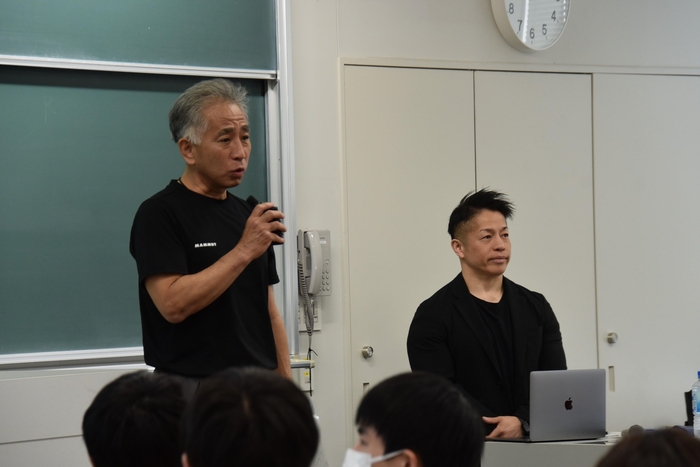 岡田教授を紹介する梅田教授(左)