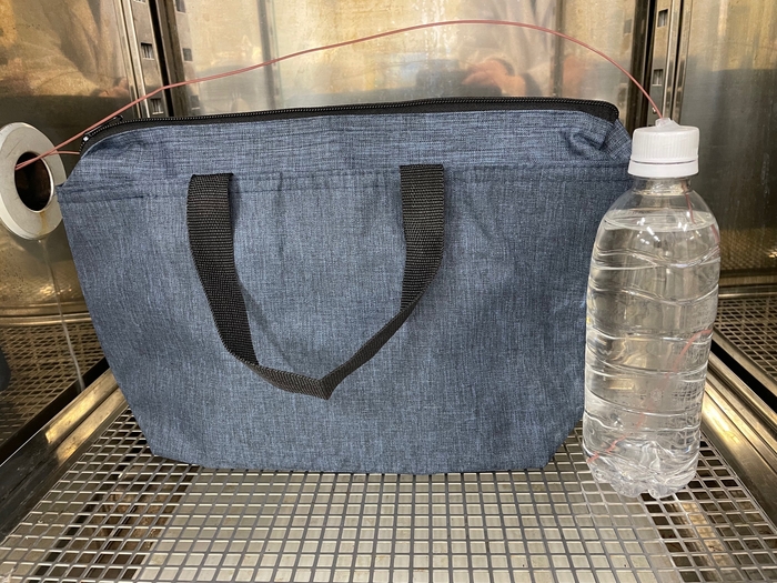 槽内での試験の様子(ペットボトル2本のうち1本を保冷バッグに収納し、それぞれに温度センサーを取り付けて温度変化を測定)