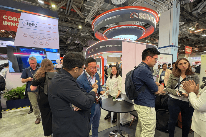 ブースを訪れた人に説明するトイメディカル株式会社代表取締役社長 竹下英徳(左)