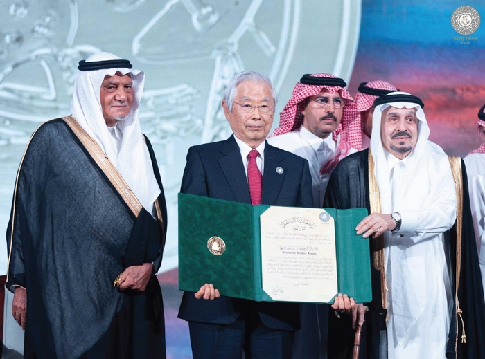 受賞の盾を手にする飯島終身教授