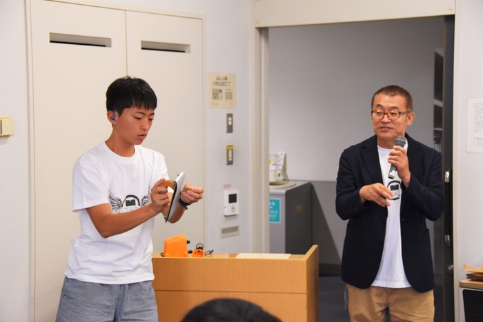 駒のやすりがけを説明する名古屋聾学校の望月秀都さん(左)と伊藤泰弘教諭