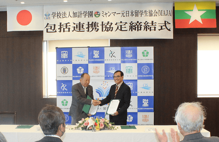 協定書に署名し、握手を交わす加計理事長(左)とミョー・キン会長