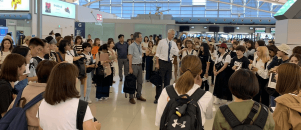 令和元年(2019年)留学出発直前に学生にメッセージを送るクレイグ学部長(関西国際空港にて)