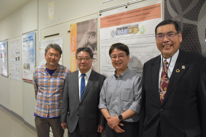 農学部応用微生物学研究室前で記念撮影(右から小原学長、加藤雅士教授、森特任教授、志水准教授)