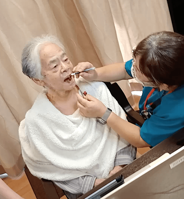 スタッフにメイクをしてもらう古賀初子さん(84歳)