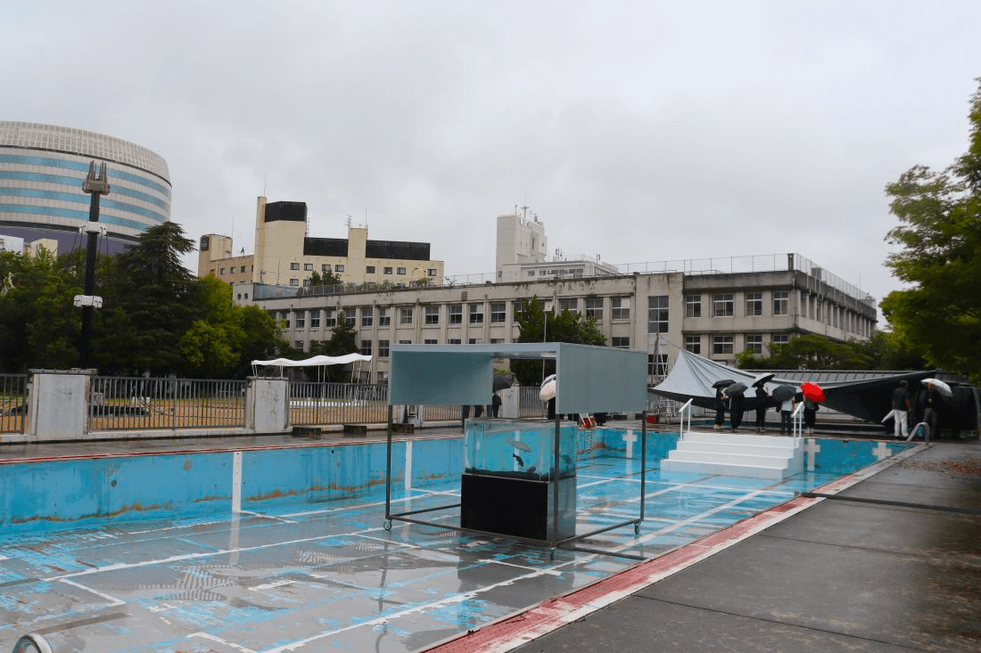 旧内山下小学校の展示会場。右奥がプール、中央が水槽、左側にあるのが展覧会のシンボルとなるAI(人工知能)を搭載した〝しゃべるタワー〟