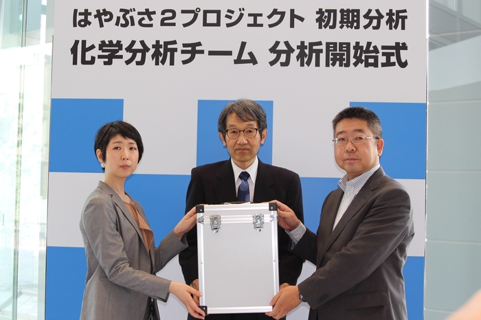 試料の引き渡し 左から、堀場テクノサービス 沼田、北海道大学教授 圦本氏、リガク 本間氏