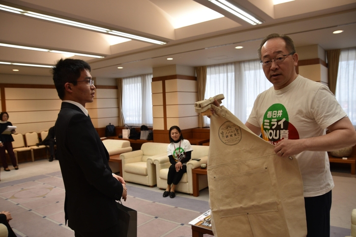 大久保さん(左)からノパルノ研究室のエプロンを手渡された石黒市長