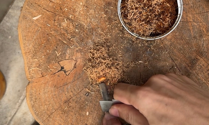 火口をメタルマッチで着火する様子