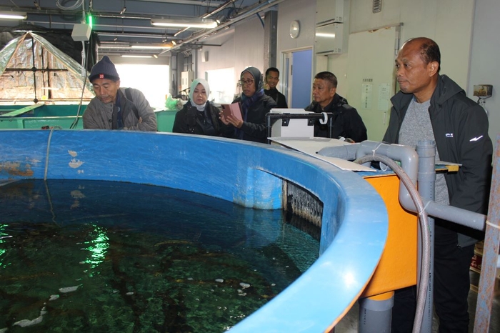 ニホンウナギの養殖水槽を視察するハエル局長(右端)