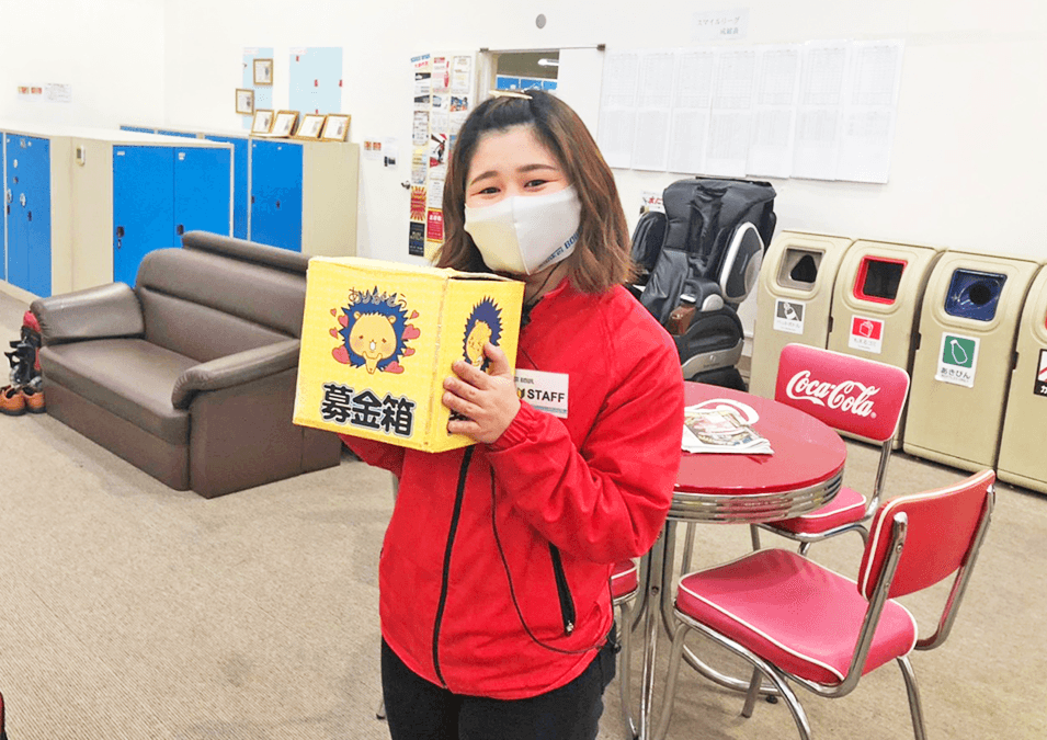 ストライク募金箱を持つスタッフ