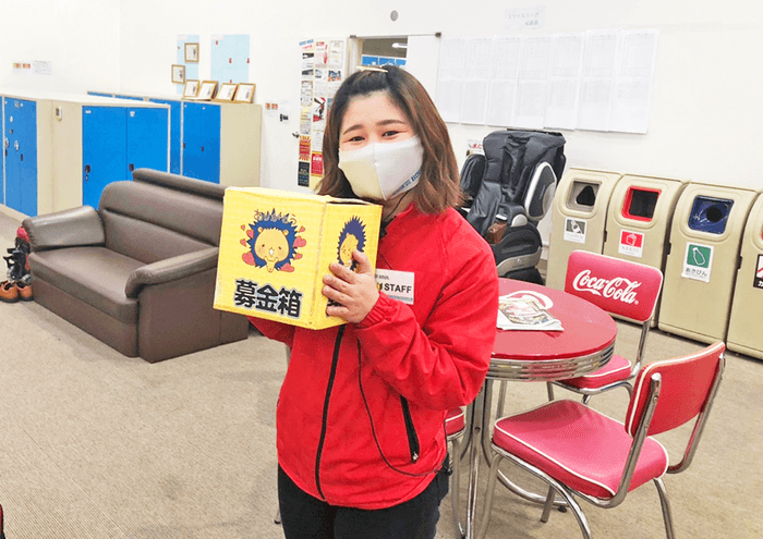 ストライク募金箱を持つスタッフ