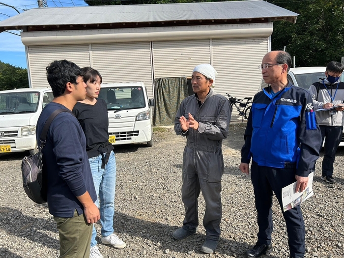 谷内支部長(右)と川原社長(右から2人目)から事情を聴くメンバー