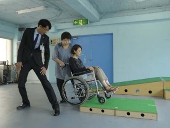 車いす使用者の介助(提供:公益財団法人日本ケアフィット共育機構)