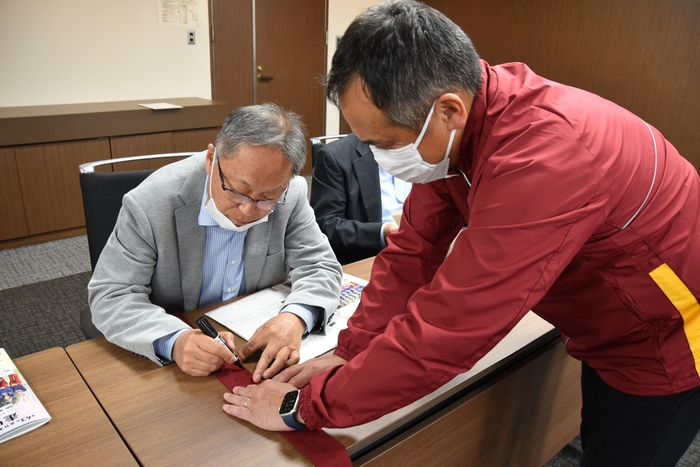 メッセージを書き入れる野口学長