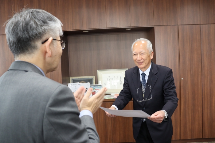 平野学長(左)から称号授与証を受け取る石垣元館長(右)