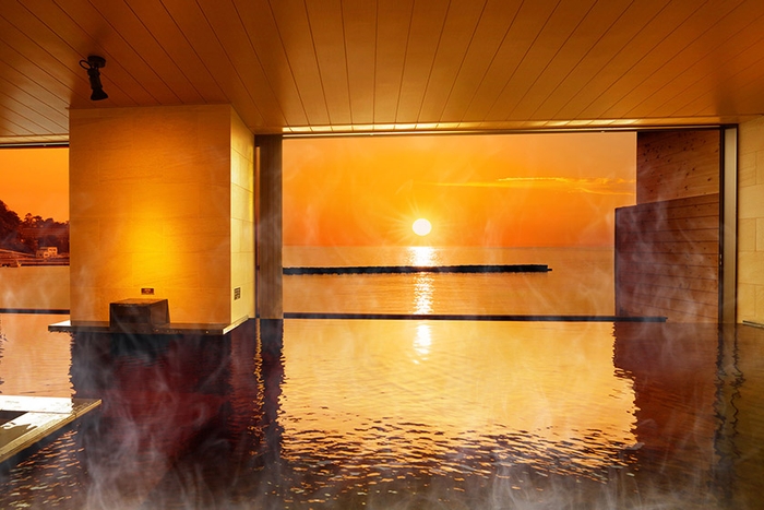 水面を黄金色に染める水平線に沈む夕日