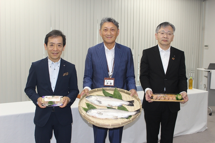 成長したベニザケ、刺身、寿司を手にする(左から)澁谷社長、伊藤社長、平野学長=福島市の「いちい」本社で7月20日