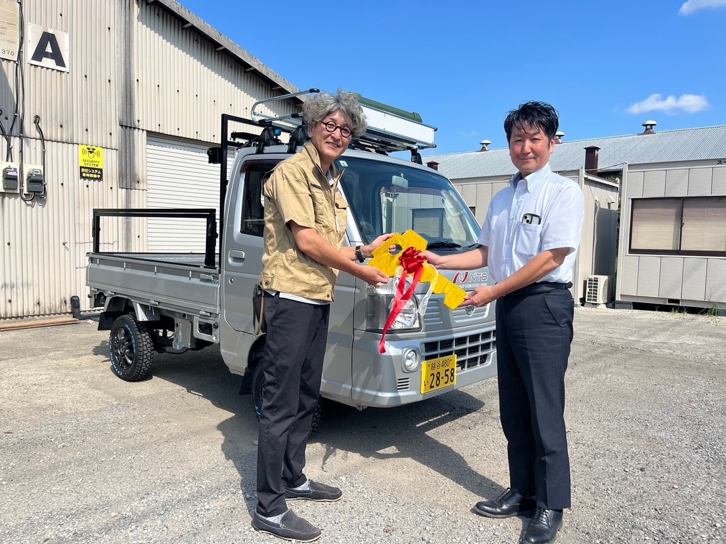 8月21日の寄贈式(左:日本ソーシャルワーク教育学校連盟 事務局長代理 小森 敦様、右:NTB 代表取締役 蜂谷 愼吾)