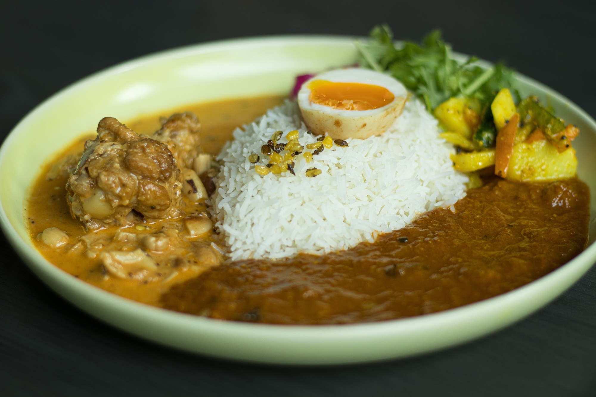 手羽元とカシューナッツのバターチキンと山西牧場三右衛門豚のポークビンダルのあいがけ