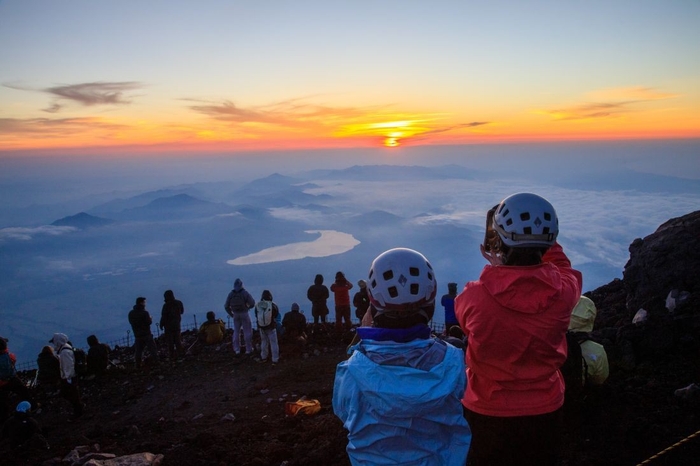 富士山頂でご来光を迎える学生たち