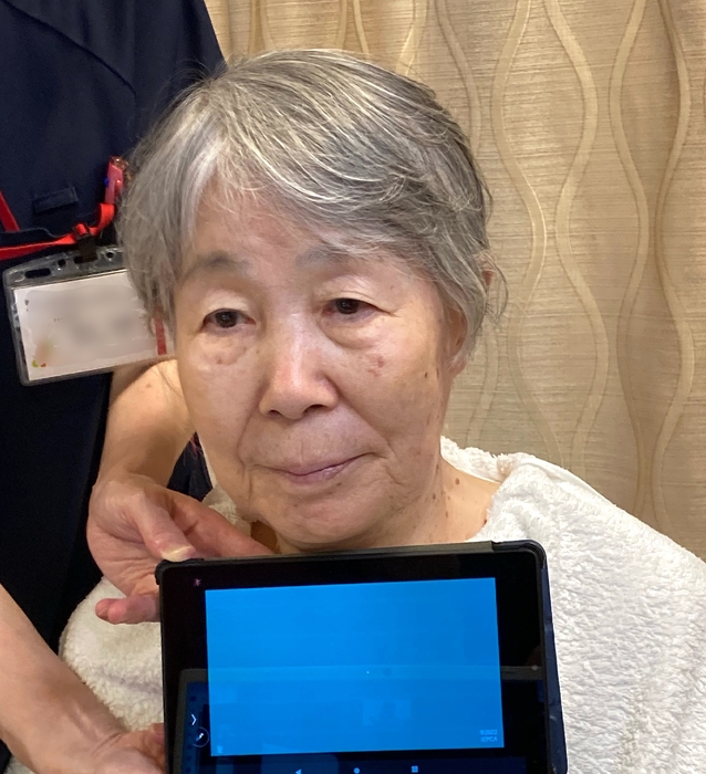 iPadでデジタルカラー診断を受ける吉村ミネ子さん(89歳)