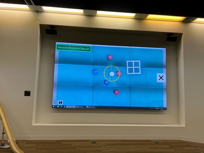 株式会社CAC Holdingsの本社1階にある、CACボッチャコート 壁面には天井カメラと連携し、ゲームの盤面を映し出す大型モニターも備える