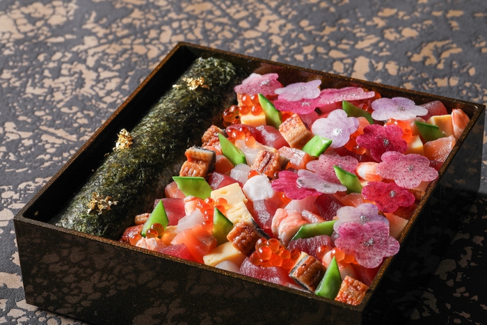 ▲参の段:マグロ、サーモン、ブリ、海老、鰻、いくら、玉子巻き、7種類の具材と、ご飯にはいぶりがっこ、茗荷の酢漬けを混ぜ合わせ、3種類の大根を花びらに見立てた迎春に相応しい彩り豊かな海鮮ちらし寿司と、和牛のしぐれ煮、ローストビーフをたっぷり使用した太巻き肉寿司