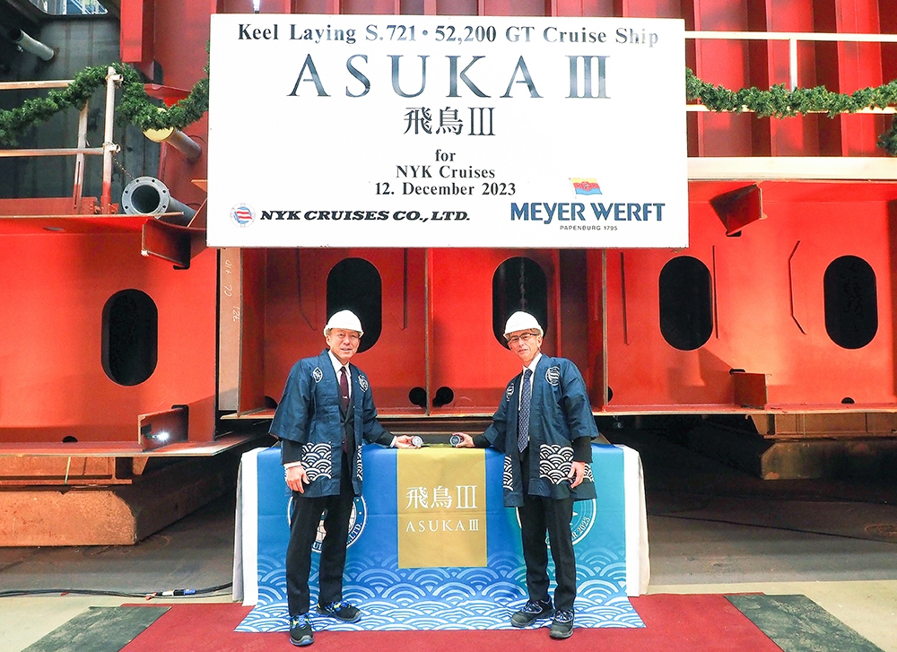 「飛鳥III」キール・レイイング セレモニー時のコイン・セレモニー 当社取締役専務執行役員 堤義晴(左)、日本郵船株式会社 常務執行役員 樋口久也氏(右)