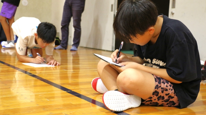 アンケートを書く小学生