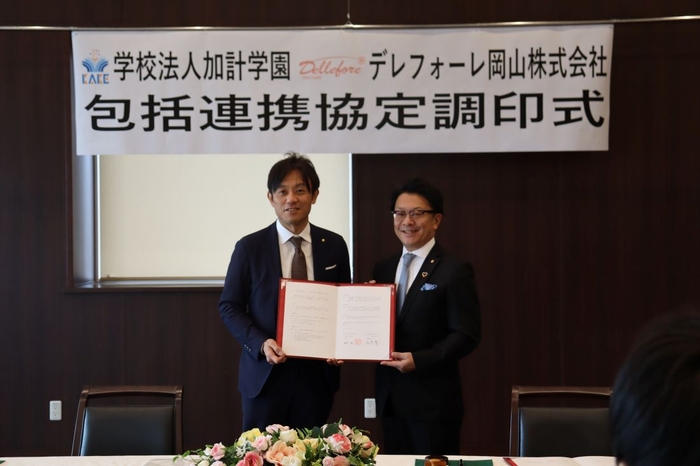 協定書を手にする(左から)加計理事長と尾崎会長