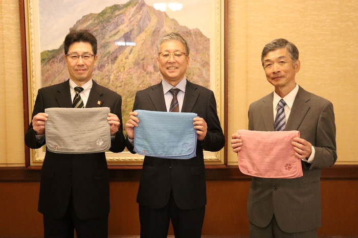 共同開発したペット用タオルを手にする(左から)菅副知事、福岡部長、村田副学部長