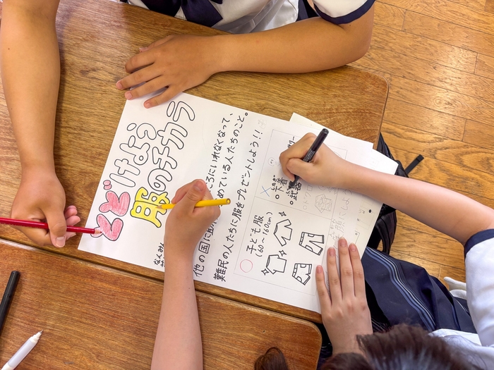 服の寄付を呼び掛けるポスターを作成する生徒たち