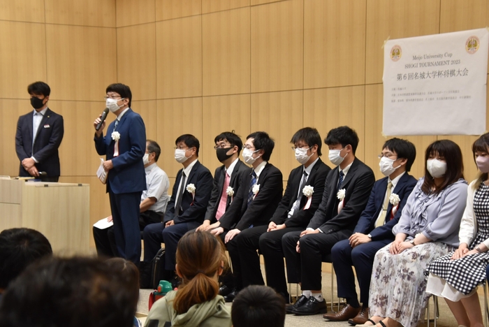 開会式であいさつする杉本八段(左から2人目)と指導対局に臨んだプロ棋士